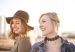 Two smiling women from NeuroSpark Health's community stand in the sunlight.