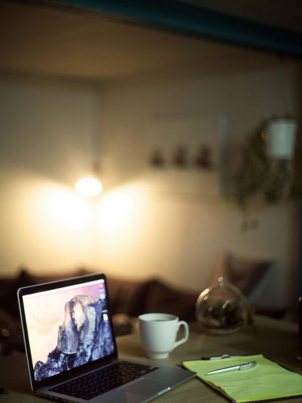 A laptop and coffee mug used in a living room while accessing accommodations support services for autistic adults at NeuroSpark Health.