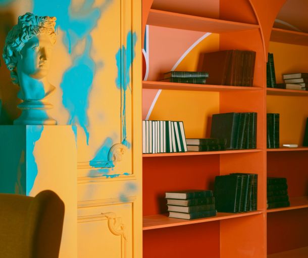 A room featuring colorful walls and bookshelves, with a statue prominently displayed, symbolizing a welcoming therapy space found through NeuroSpark's inclusive therapy directories.