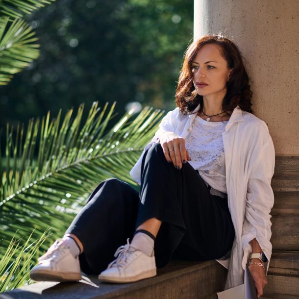 A woman sits on a ledge, considering "Is A Formal Evaluation Right For Me?" with a thoughtful expression.