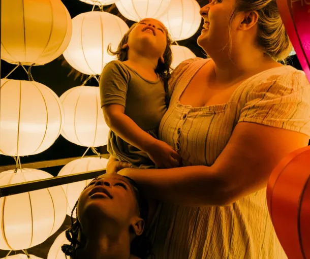 Woman with two kids looking at a sensory light exhibit and considering autism assessment using the MIGDAS-2.