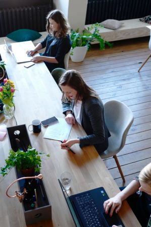 People work individually in a communal office space applying for NeuroSpark Health careers.