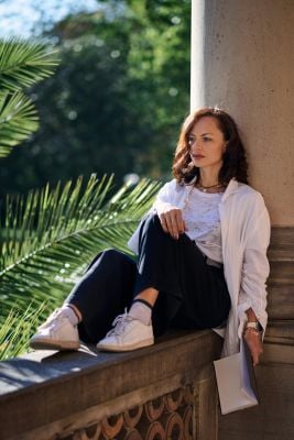 A woman sits on a ledge, considering "Is A Formal Evaluation Right For Me?" with a thoughtful expression.