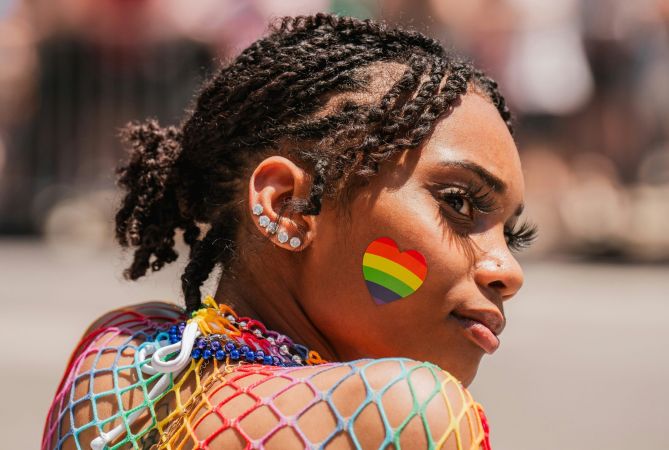 Woman with rainbow face paint represents NeuroSpark Health careers.
