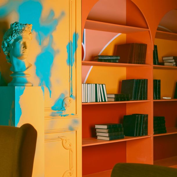 A room featuring colorful walls and bookshelves, with a statue prominently displayed, symbolizing a welcoming therapy space found through NeuroSpark's inclusive therapy directories.