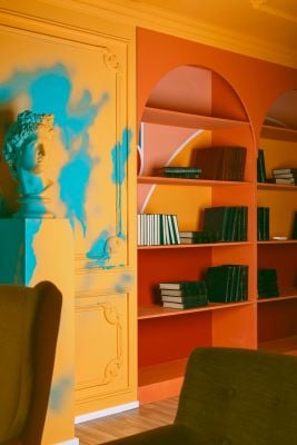 A room featuring colorful walls and bookshelves, with a statue prominently displayed, symbolizing a welcoming therapy space found through NeuroSpark's inclusive therapy directories.