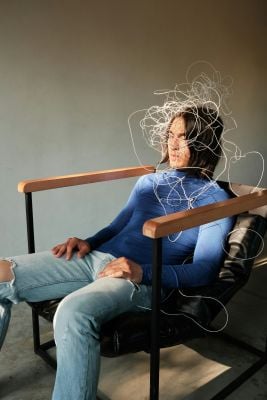 A man sits in a chair with wires on his head, symbolizing a need for adult ADHD resources and support.