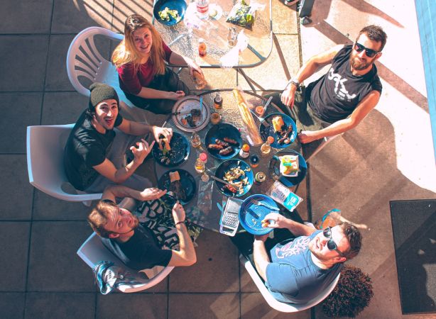 A group of friends are photographed from above as they discuss NeuroSpark Health careers.